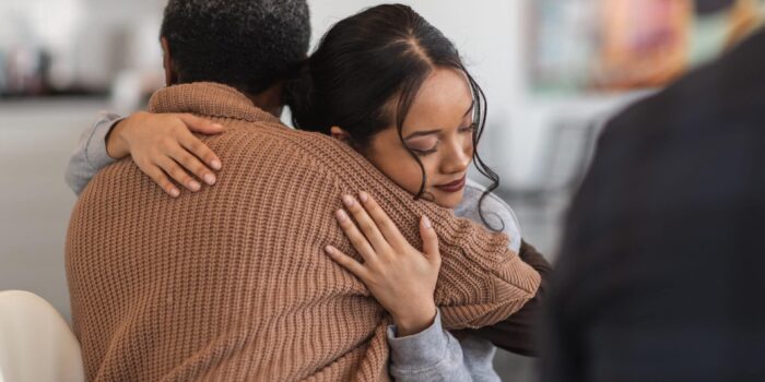 Women hugging her recovery coach during a meeting